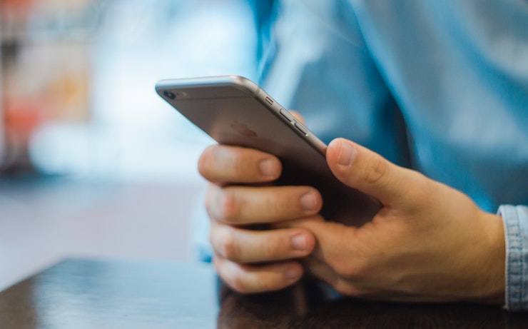 Man looking at apps on his iphone for giftcards