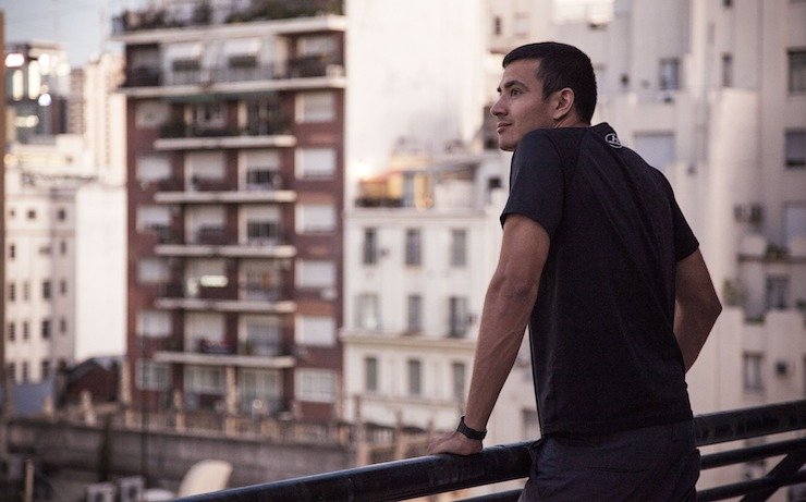 Man looking out to a city buildings full of apartments