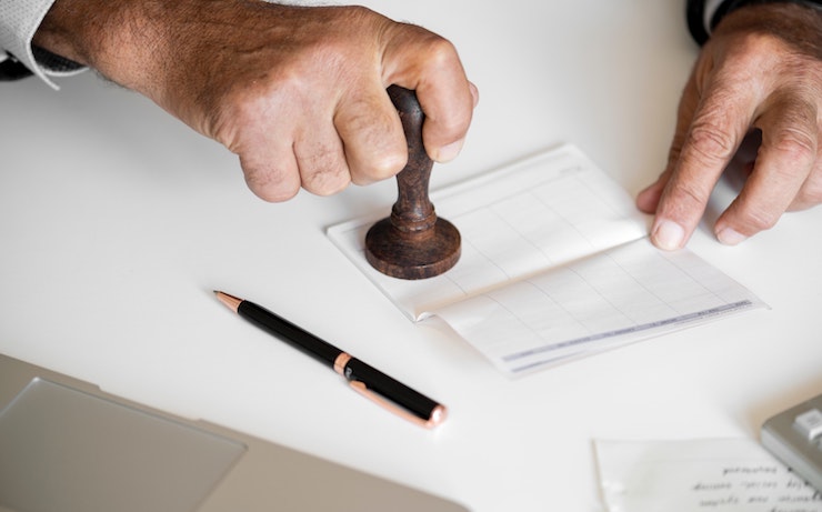 Man stamping a check with a notary stamp