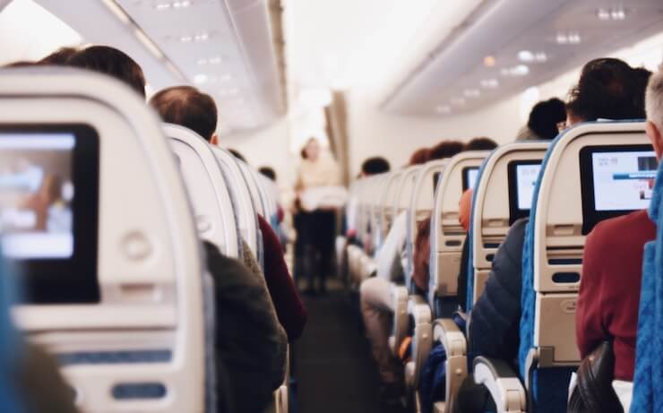 Photo of an airplane aisle full of passengers