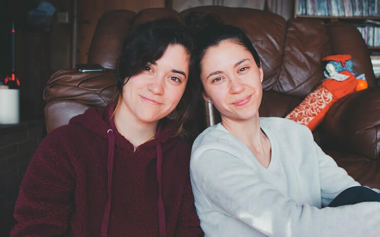 Two girls hanging out at a house by a couch