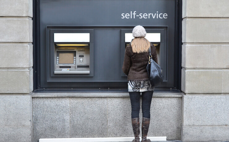 Woman using a self-service ATM machine at a bank